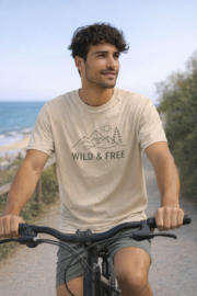 Man wearing the natural Wild & Free Mountain Tee while cycling outdoors