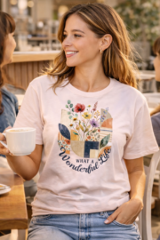Woman wearing a What a Wonderful Life botanical t-shirt at a café