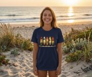 Woman wearing a navy Retro Surf Rack T-shirt on the beach at sunset.