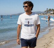 Man wearing the white Paddle Club coastal T-shirt on the beach.