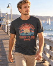 Man walking on a coastal pier wearing the Dark Heather Malibu Surf Club graphic T-shirt
