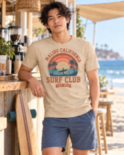 Man at a beach café wearing the Sand Malibu Surf Club graphic T-shirt