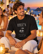 Man seated with friends by an Ibiza pool wearing the black Ibiza graphic T-shirt