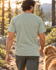 Back view of a man wearing the plain Bay Trail Club tee while walking with a dog on a wooded trail.