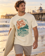 Man carrying a surfboard in an ivory Santa Cruz California surf T-shirt