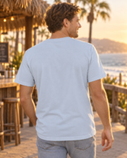 Back view of a model wearing the California Surf T-shirt in light blue by the coast.