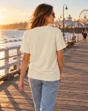 Back view of a woman wearing a blank ivory Comfort Colors 1717 T-shirt on the Santa Cruz pier