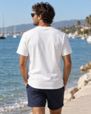 Man wearing the white Comfort Colors 1717 Paddle Club T-shirt from the back by the sea.