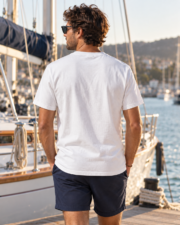 Man wearing the white Comfort Colors 1717 Yacht Club T-shirt from the back beside a sailboat.