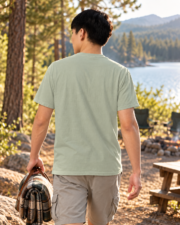 Back view of a man wearing the plain Bay camping tee while walking at a lakeside campground