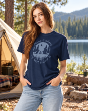 Woman wearing the True Navy camping dog graphic tee beside a lakeside tent, front view