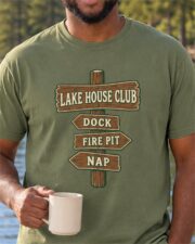 Man wearing the Moss Lake House Club Signpost T-shirt with a coffee mug by the lake, close-up