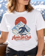 Woman wearing the White Après Ski Club Skier T-shirt on a sunny ski lodge deck