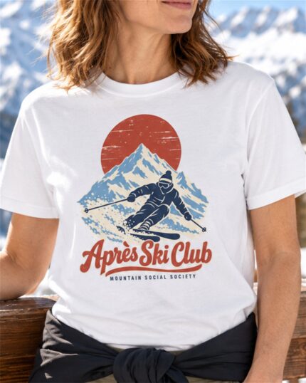 Woman wearing the White Après Ski Club Skier T-shirt on a sunny ski lodge deck