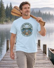 Man walking a misty lake dock with canoe paddles in the Chambray Lake House Club Crest T-shirt