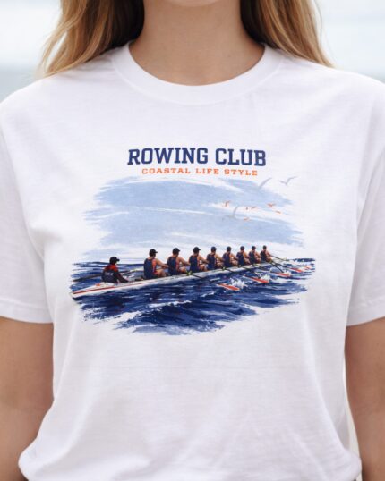 Close-up of a woman wearing the white Rowing Club coastal T-shirt by the water.