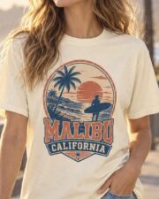 Woman wearing the ivory Malibu California Surf Tee on a Malibu beachfront promenade at sunset