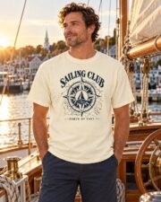Man wearing the Sailing Club Compass Rose T-shirt aboard a classic wooden sailboat