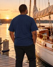 Back view of the True Navy Sail Plan T-shirt on a man on the dock at sunset