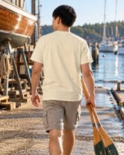 Back view of the Ivory Anatomy of a Sailboat T-shirt on a man carrying oars