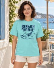Woman wearing the Lagoon Blue Beneath the Blue scuba diver T-shirt by the sea